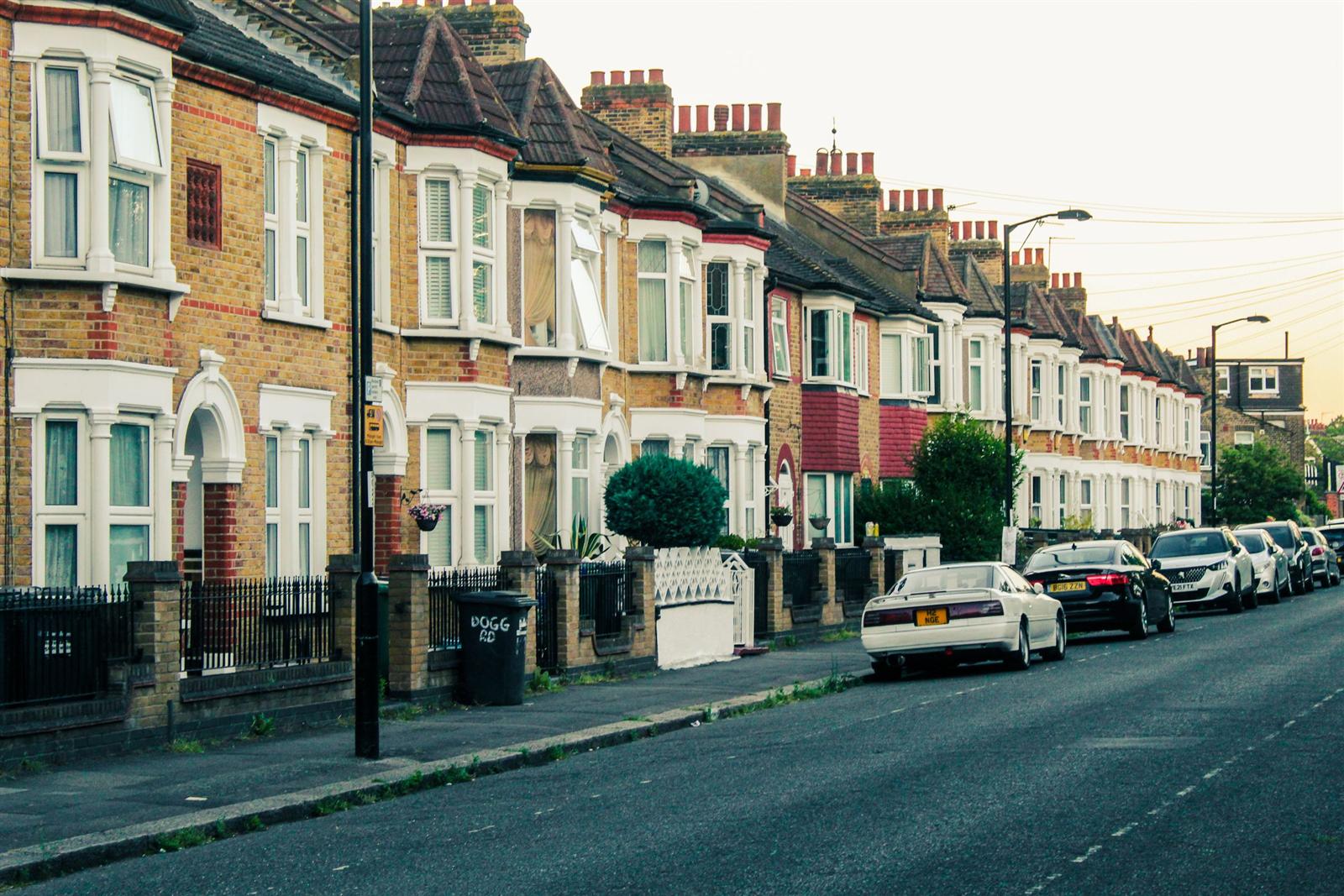 A quiet terraced street at dusk, cars parked for the evening