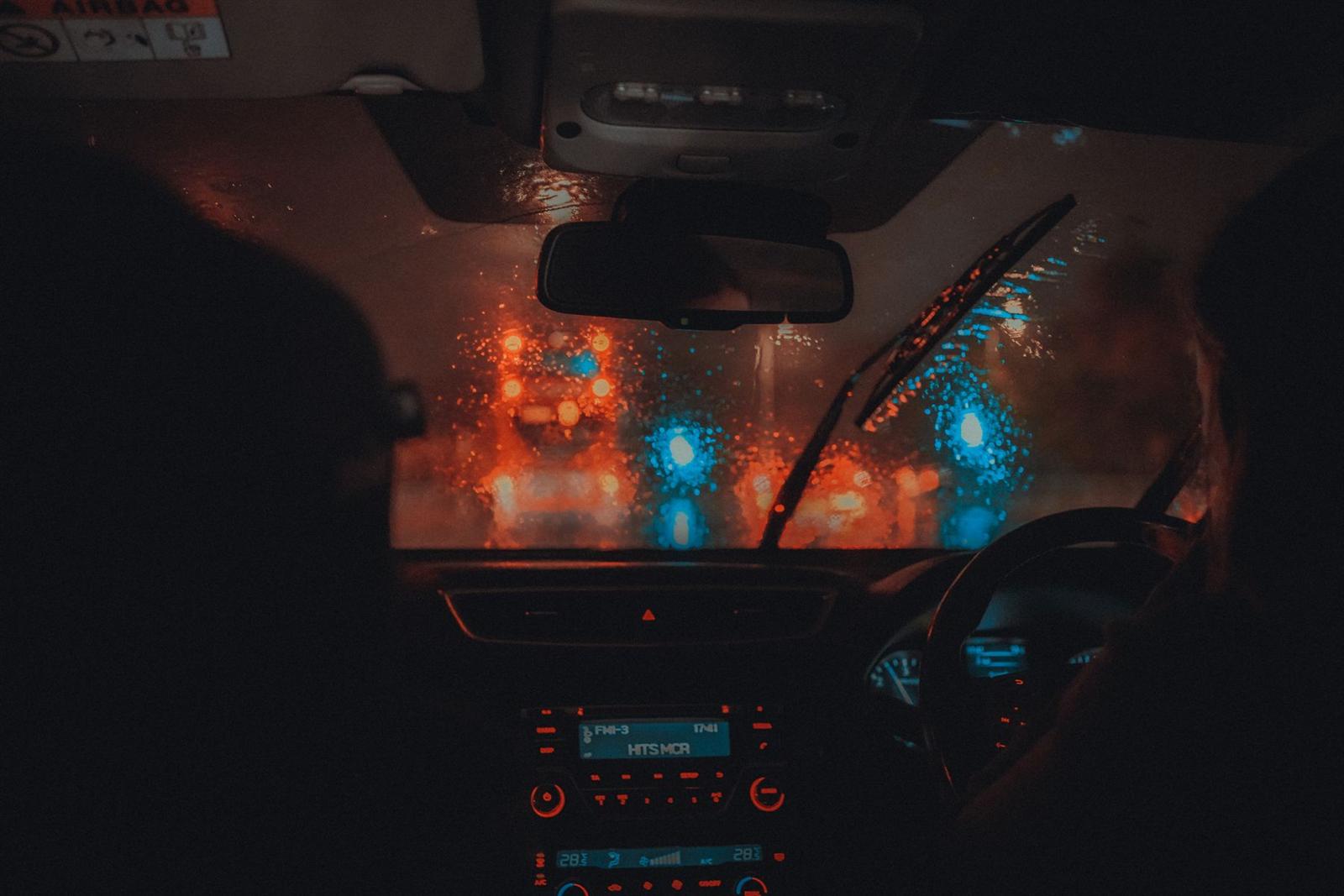 Hands on the wheel at night, city lights ahead