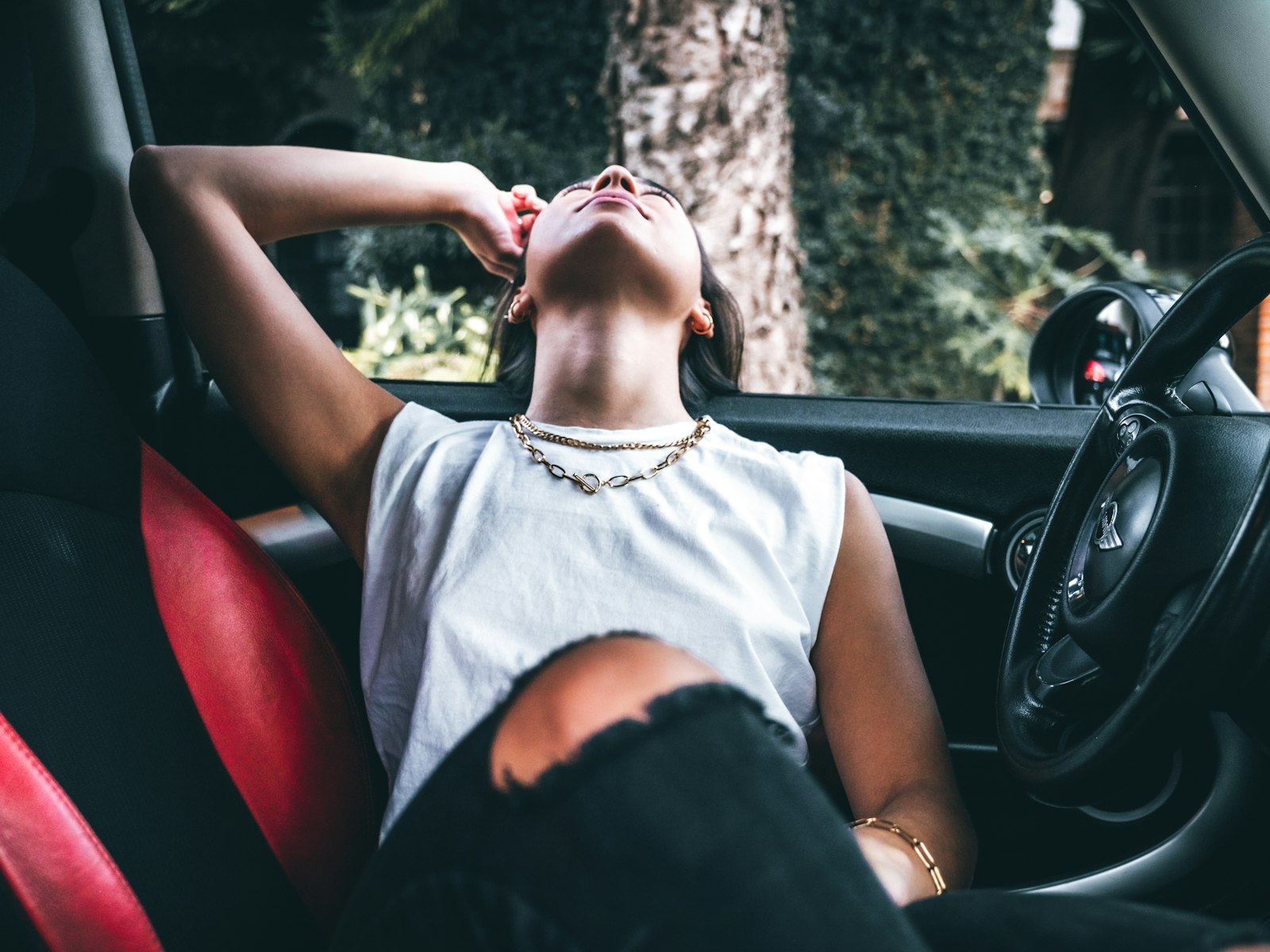 A young woman leaning back in her Mini, completely at ease